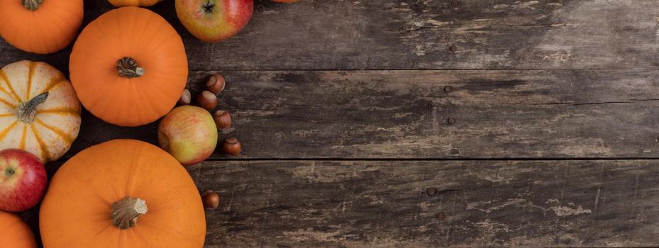 Autumn food background, pumpkin, apple, nut on old tabletop background with copy space for text