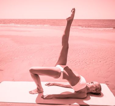 Woman doing yoga asana at the beach