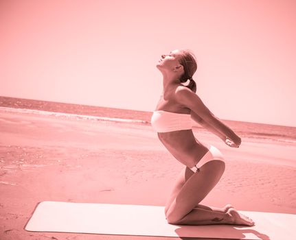 Woman doing yoga asana at the beach