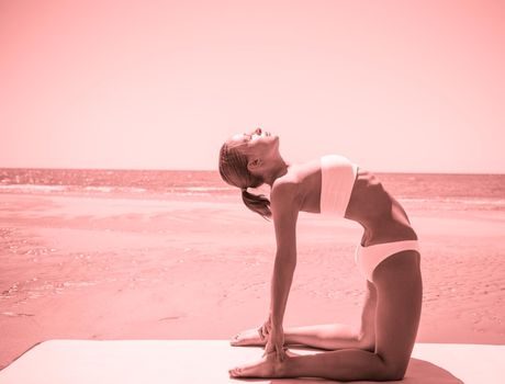Woman doing yoga asana at the beach