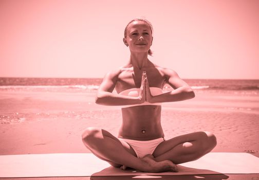 Woman doing yoga asana at the beach