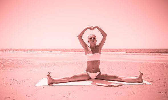 Woman doing yoga asana at the beach