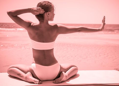 Woman doing yoga asana at the beach