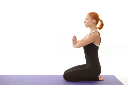 Young woman in meditation pose with eyes closed over white background