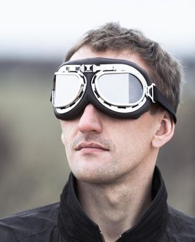 Young man wearing aviator motorcycle glasses at the airfield