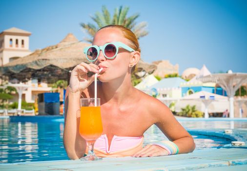 Girl in pool bar at tropical tourist resort vacation destination