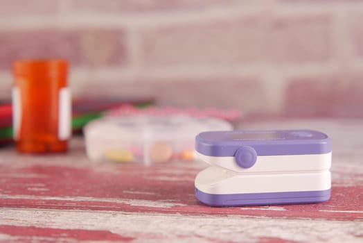pulse oximeter, medical pills and blister pack on table .