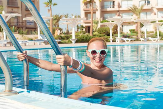 Young woman enjoying warm water in pool at tourist resort