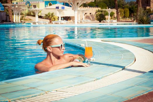 Girl in pool bar at tropical tourist resort vacation destination