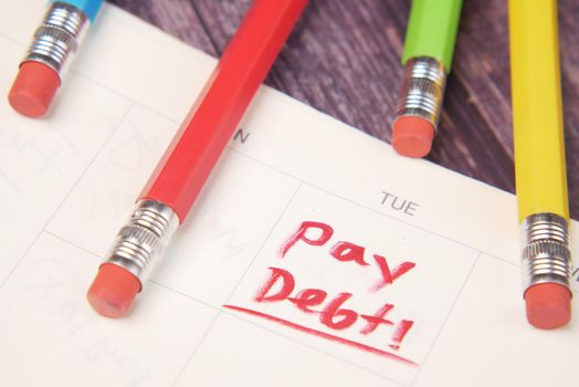 Close up of pay debt word on calendar.