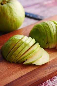 close up of slice of guava on a chopping board