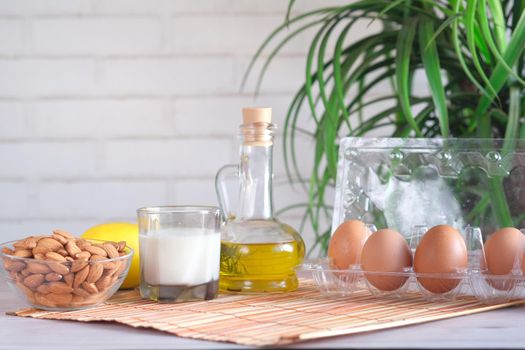 eggs in a plastic container, milk and almond nut in table ,