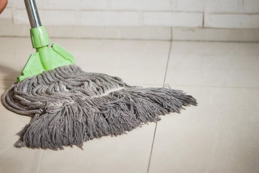 cleaning tiles floor with mop .