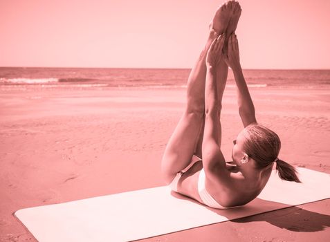 Woman doing yoga asana at the beach