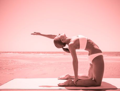 Woman doing yoga at the beach