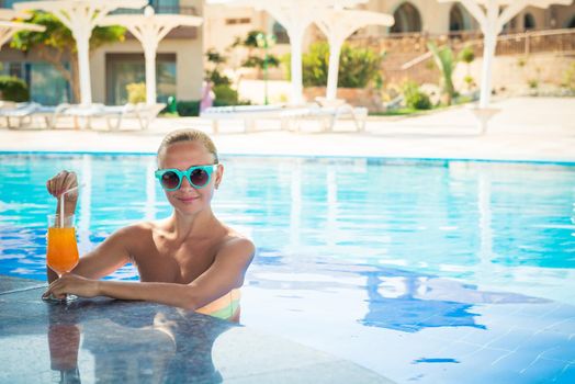 Girl in pool bar at tropical tourist resort vacation destination