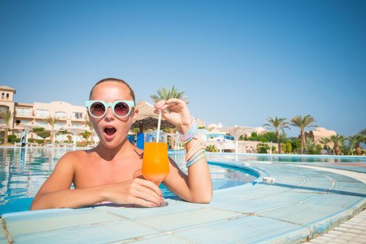 Girl in pool bar at tropical tourist resort vacation destination