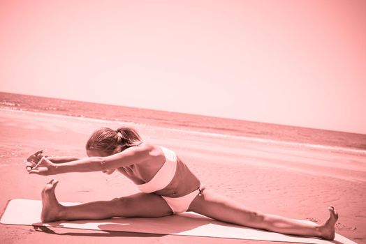 Woman doing yoga asana at the beach