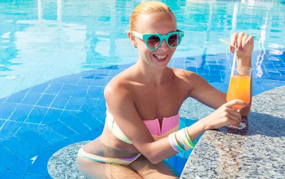 Girl in pool bar at tropical tourist resort vacation destination