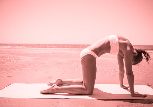 Woman doing yoga asana at the beach