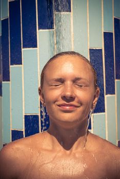 Sensuous slim woman taking shower at the beach