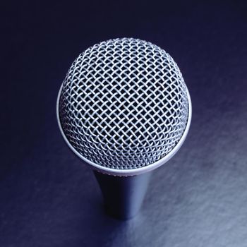 Microphone on black background top view close up