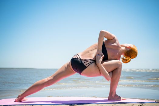 Woman doing yoga asana at the beach