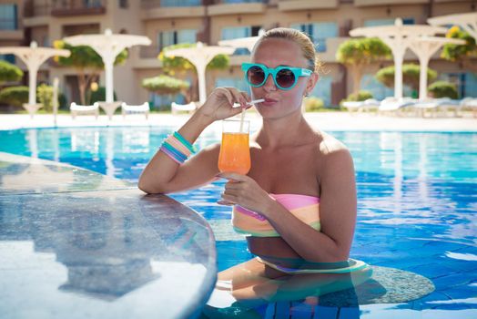 Girl in pool bar at tropical tourist resort vacation destination