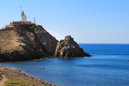 Beautiful Corralete beach and Cabo de Gata lighthouse in the background on a sunny day of summer