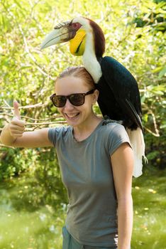 Exotic bird on a womans shoulder at Bali, Indonesia