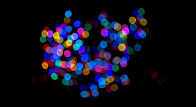 Colorful group of holiday lights on dark background of night