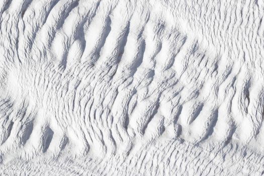White texture of Pamukkale calcium travertine in Turkey, diagonal pattern, close-up.