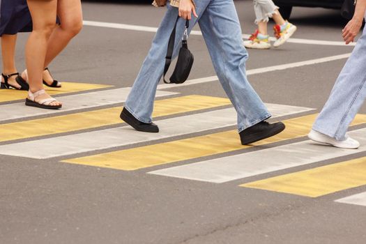 pedestrians walking on a crosswalk on sunny summer day