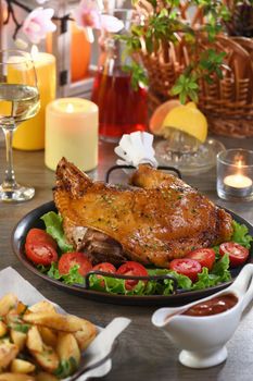 Baked turkey drumstick on a vegetable tray on a festive dinner table in honor of Thanksgiving.