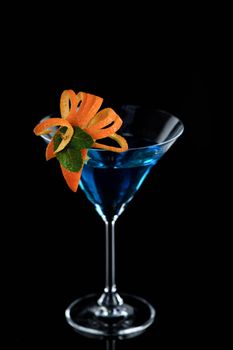 Decoration for a cocktail of orange and mint. Elegant and original presentation. Martini Blue Curacao on a black background