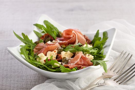 Arugula salad, prosciutto with sun-dried tomatoes, slices of mozzarella, capers, seasoned with olive butter and parmesan. A dish for those who monitor their health