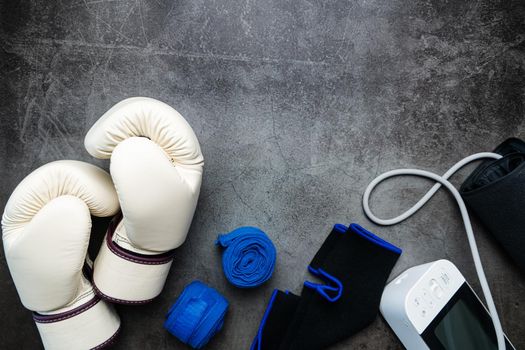 Boxing glove, sphygmomanometer, fitness equipment on a dark background with copy space