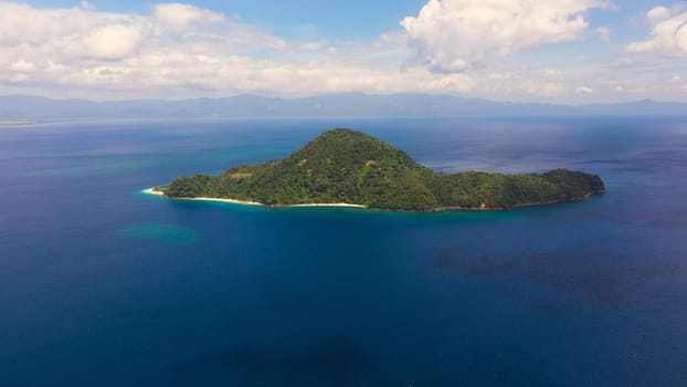 Tropical island and blue sea, aerial view. Atulayan Island, Camarines Sur, Philippines. Seascape with a green island. Summer and travel vacation concept.
