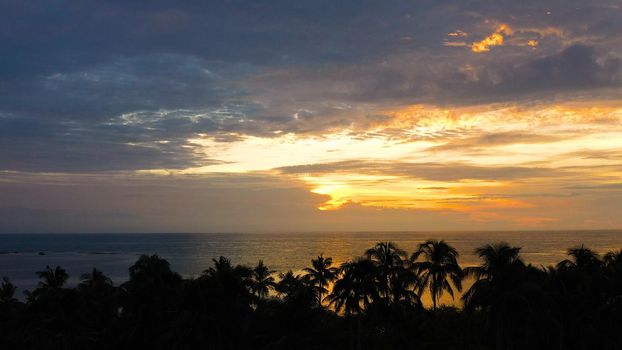 Sunrise on a tropical island with palm trees. Tropical island during sunrise.Early morning in the tropics. Philippines, Anda, Pangasinan. Travel concept.