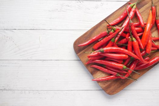 red chili on a chopping board on table with copy space .