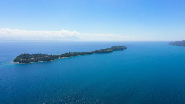 Top view of small tropical Big Liguid Island in the blue sea with a coral reef and the beach. Big Cruz Island, Philippines, Samal.