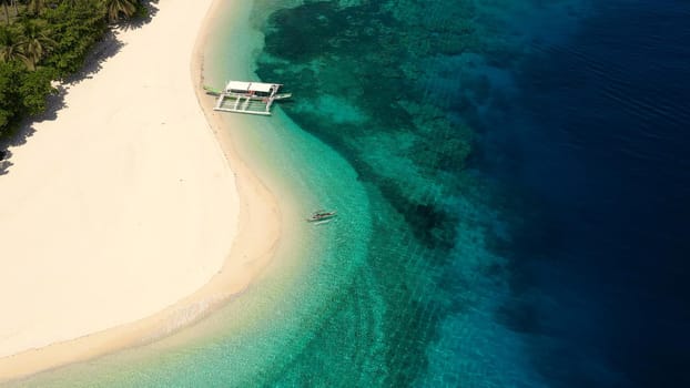 Seascape with a beautiful tropical island, aerial view. Beautiful white sand beach. Mahaba Island, Philippines. Blue sea with turquoise lagoons. Summer and travel vacation concept.