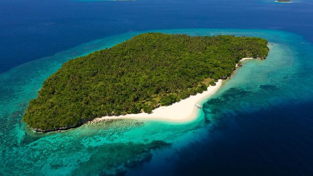 Atoll with a beautiful island, aerial view. White sand beach and blue sea. Mahaba Island, Philippines. Summer and travel vacation concept.