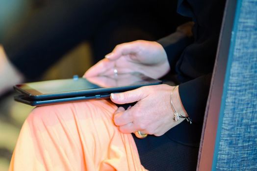 Smart tablet with hands on lap close up