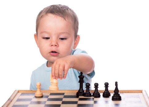 little boy staring at the chess pieces