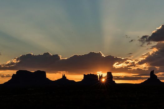 Artistic Utah Monument Valley mesa silhouette panorama at sunset with holy light heavenly godly spiritual
