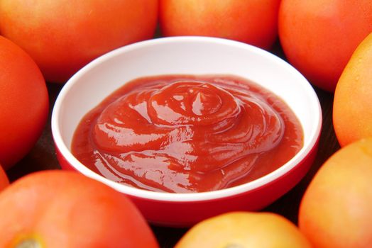 tomato sauce in a small jar with fresh tomato on table ,