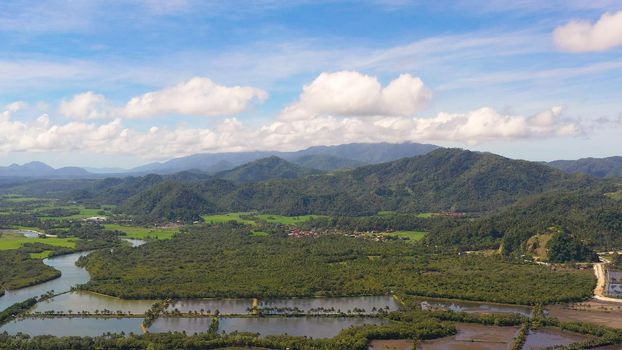 Tropical landscape: a town at the foot of mountains and hills covered with tropical vegetation and forest. Philippines, Mindanao. Surigao City.