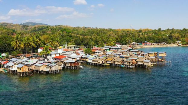 Village of fishermen with houses on the water, with fishing boats. Fishing village with wooden houses on stilts in the sea. Philippines, Mindanao.