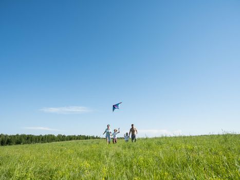 Family Flying Kite Together Outdoors in summer meadow love parenting Concept